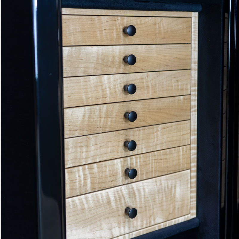 Detail — seven curly maple drawers with matte black pulls